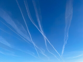 contrails from an airplane in the blue sky, geoengineering