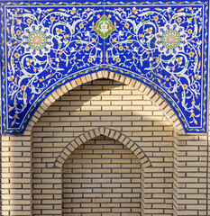 Part of traditional Uzbek mosaic of madrasah, pattern of blue and orange flowers and leaves at...