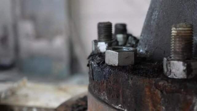 Closeup of repairman's hand installing bolts.  Worker's hand tightens nut. 
