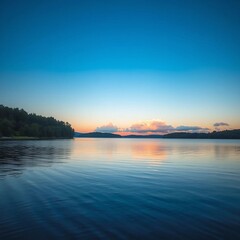 A serene lake at sunrise, with blue skies and reflected clouds.