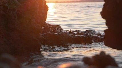 Red calm sea sunset and stones, slow motion