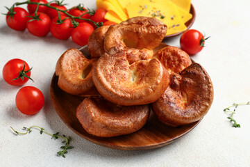 Plate with tasty Yorkshire pudding on light background