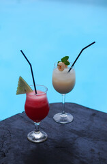 Drinks and snacks are served at tables with a swimming pool in the background