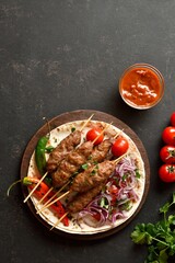 Grilled lula kebab with fresh vegetables on flat bread
