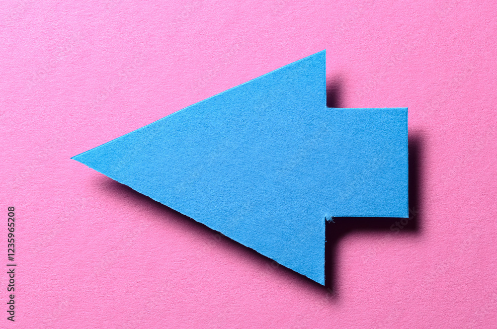 Poster blue cut out blank paper cardboard arrow direction sign with copy space for text on pink background,