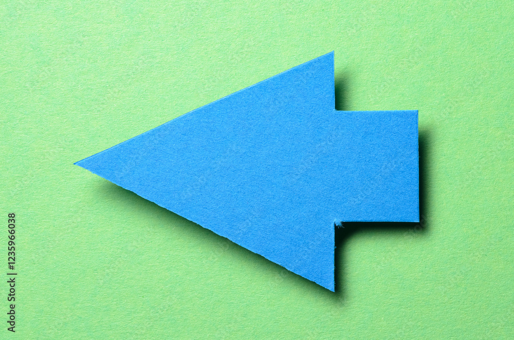 Poster blue cut out blank paper cardboard arrow direction sign with copy space for text on green background