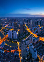 Aerial view of Shanghai skyline and bright city streets at dawn