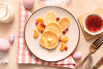 Funny Easter bunny pancakes with painted eggs on beige background