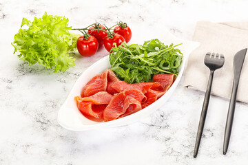 Sliced salmon with fresh arugula