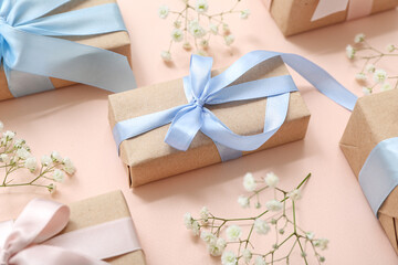 Festive composition with wrapped gift boxes and spring flowers on beige background