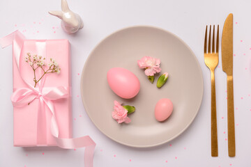 Cute Easter table setting with pink gifts, flowers and eggs on white background