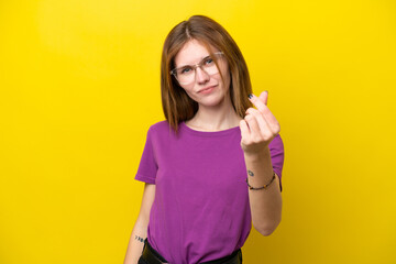 Young English woman isolated on yellow background making money gesture