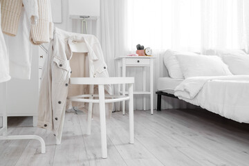 Interior of light bedroom with chair and table