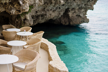 Obraz premium Scenic coastal seating area with turquoise waters nearby