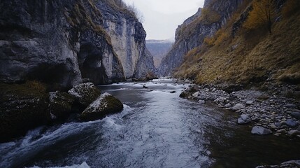 River flows through a rugged mountain canyon with autumn vegetation