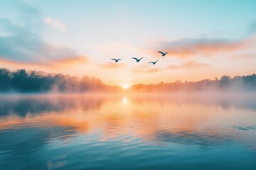 Obraz premium Serene lakeside sunrise with mist rising and birds gliding over calm water
