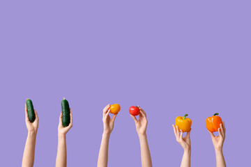 Female hands holding fresh vegetables on lilac background