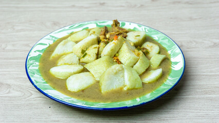 Soto daging (Indonesian meat soup) with lontong (rice cake) in indoneisan plate