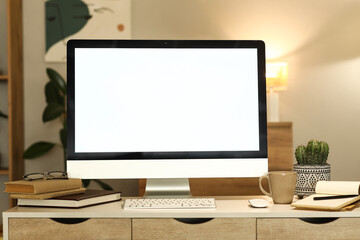 Blank computer monitor on desk in dark office