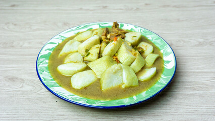 Soto daging (Indonesian meat soup) with lontong (rice cake) in indoneisan plate