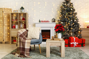 Armchair and coffee table with Christmas flower poinsettia in interior of living room