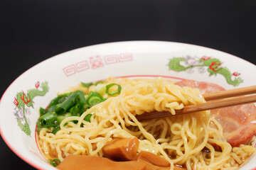 Trying to eat warm soy sauce ramen with chopsticks.