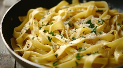 Stir-fried yellow noodles in a frying pan, ready to be served, with fresh herbs adding color and flavor.