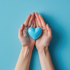 Obraz premium Female hands on a blue background holding a blue heart. The concept of donations and family insurance, World Heart Day. valentine's day.
