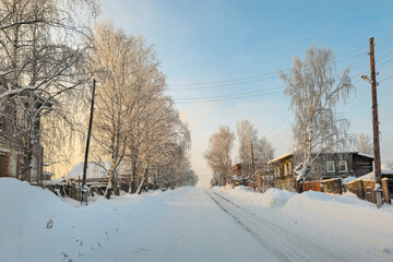 Fototapeta premium Slippery winter road. Winter evening village.