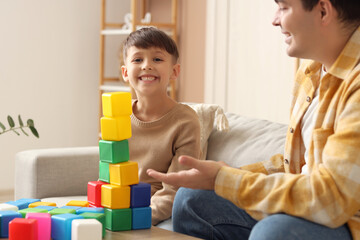 Obraz premium Little boy and his father playing with cubes at home