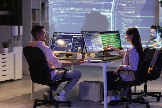 Team of young programmers working in office at night