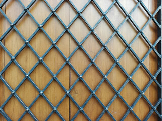 Fototapeta premium Metal grid on the wooden door