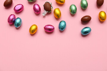 Unpacked and wrapped chocolate Easter eggs in foil on pink background
