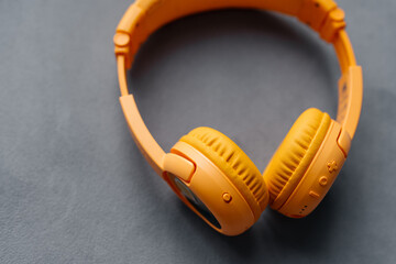 Children's headphones yellow on a gray background. Music and wireless technologies.