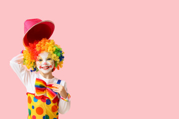 Little girl in clown costume with hat on pink background. April Fools' Day celebration