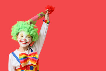 Little girl in clown costume on red background. April Fools' Day celebration