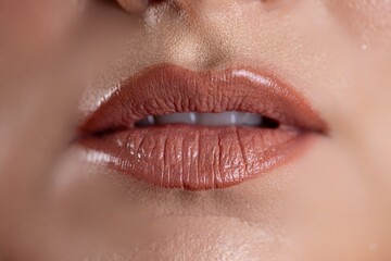 Fototapeta premium A closeup of glossy lips with nude color that enhances their natural beauty attractively