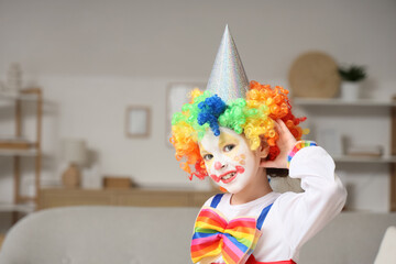 Little girl in clown costume at home. April Fools' Day celebration