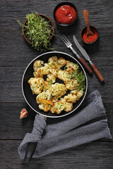 fried cauliflower florets on a skillet, top view