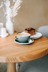 Delicious latte and dessert on a wooden table in a cozy cafe with warm ambiance