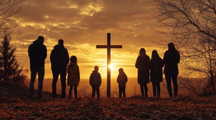 Group of people standing in silhouette, facing cross during sunrise or sunset. A moment of reflection and unity.