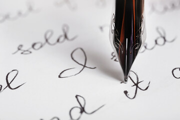 Fototapeta premium Paper sheet with letters and nib pen, closeup