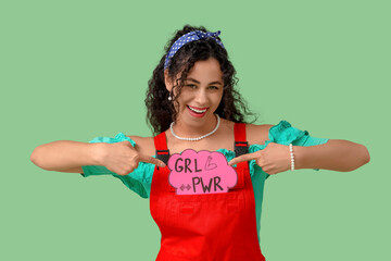 Young African-American pin-up woman pointing at GRL PWR sign on green background. Women's History...