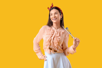 Young pin-up woman with cross wrench on yellow background. Women's History Month