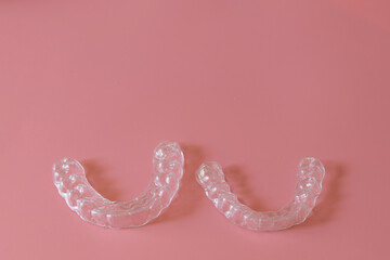 Transparent aligners, invisalign bracer smile isolated on pastel light pink background.