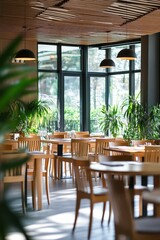 Obraz premium Dining area with wooden tables and chairs in modern cafe, bright natural light through large windows, greenery and plants creating a relaxing atmosphere.