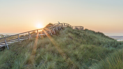 Sonnenuntergang mit Düne und Aussichtspunkt am Nordseestrand