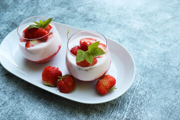 Red strawberries with whipped cream dessert on blue background
