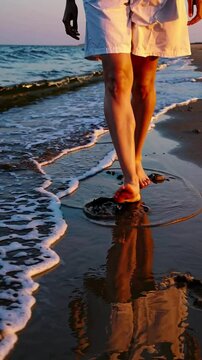 Tracking shot Bare feet walking along the shoreline leaving imprints,  warm, golden tones, late-afternoon light, reflective and grounded mood.