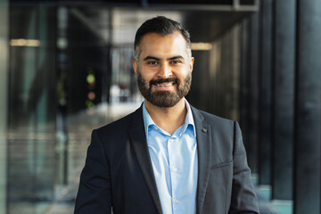 Confident Indian businessman smiling in a corporate office. Professionalism and success